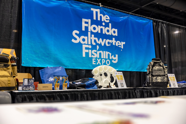 Branded backpacks, Salt Life and Smith gear line the swag table welcoming guests to the Florida Saltwater Fishing Expo.