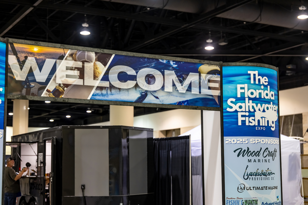 The welcome entrance banner lists 2025 sponsors like Wood Craft Marine and Backwater Provisions Co. at the Florida Saltwater Fishing Expo.
