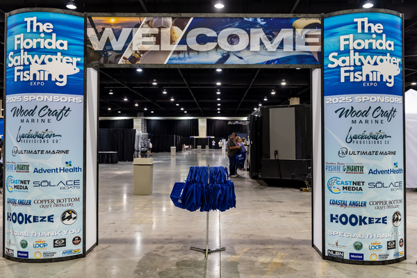 The Welcome archway lists 2025 sponsors like Wood Craft Marine and Copper Bottom Craft Distillery at the Florida Saltwater Fishing Expo.