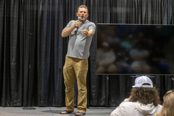 A Hunt. Fish. Eat Meat. seminar speaker points to the crowd while addressing attendees at the Florida Saltwater Fishing Expo.