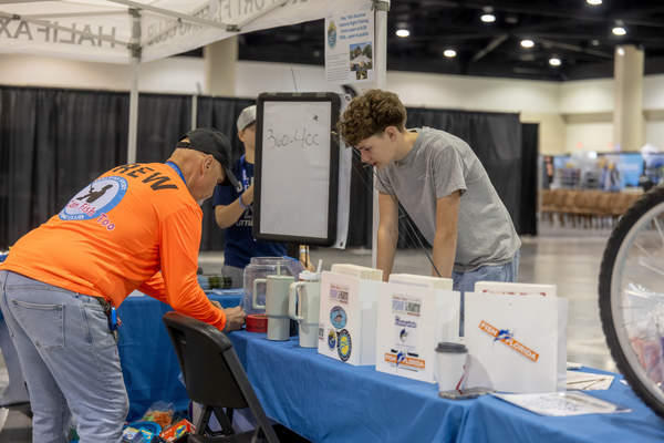 A Halifax Sport Fishing Club volunteer sets out Fish Florida stickers and magazines for a young visitor at the Florida Saltwater Fishing Expo.
