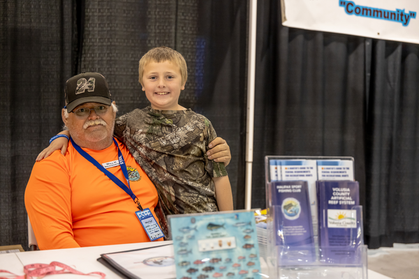 Halifax Sport Fishing Club weighmaster Will H poses with a young angler at the Florida Saltwater Fishing Expo.