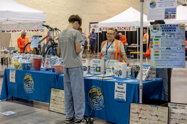 A teen signs up for the Next Generation Angler Zone at the Halifax Sport Fishing Club's raffle table at the Florida Saltwater Fishing Expo.