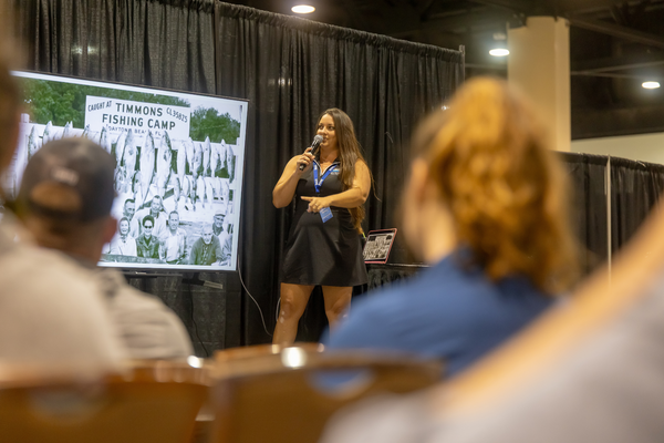 A speaker shares a historic photo from Timmons Fishing Camp in Daytona Beach during a seminar at the Florida Saltwater Fishing Expo.