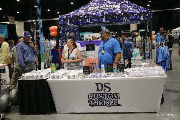 Shoppers browse the DS Custom Tackle and Benjamins Beach Wheels booths in a lively aisle at the Florida Fishing Expo.