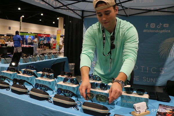 An Island Optics team member arranges polarized sunglasses at his Florida Fishing Expo booth.