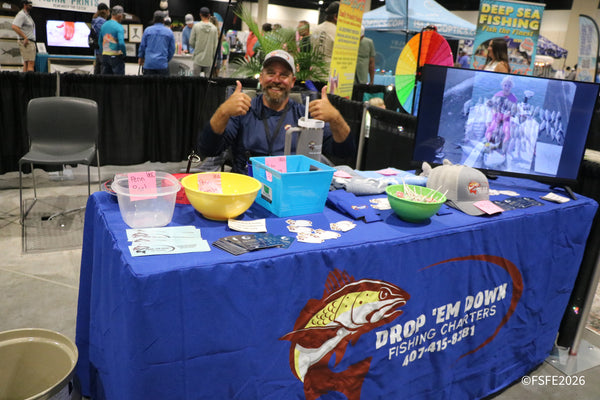 A smiling Drop 'Em Down Fishing Charters vendor gives two thumbs up from his booth at the Florida Fishing Expo.