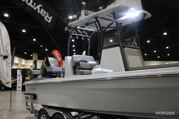 An Insetta Boatworks hydro-foil assisted catamaran on display, with attendees checking out the helm at the Florida Fishing Expo.