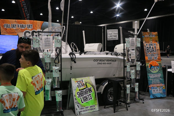 A dad and his kids check out the CCF Boat Rentals display and Shrimpin' Lights gear at the Florida Fishing Expo.