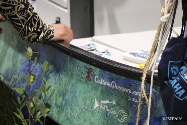 A custom camo-wrapped Gheenoe skiff featuring Bull Bay Rods branding on display at the Florida Fishing Expo.