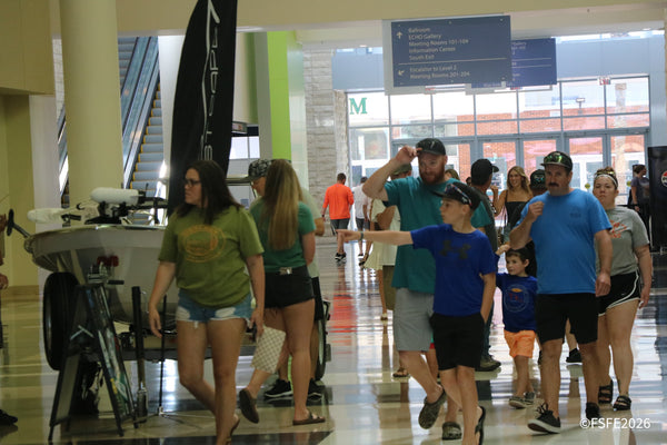 Families stream through the Ocean Center lobby toward the Florida Fishing Expo show floor, kids pointing excitedly ahead.