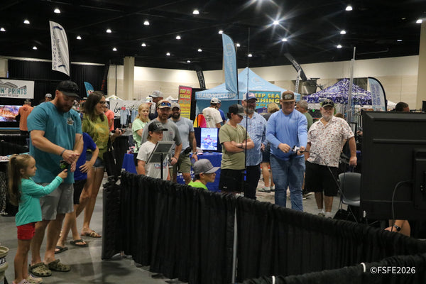 A big, happy crowd — including kids trying out rods — packs the aisle near Islamorada Flyers and Island Optics at the Florida Fishing Expo.