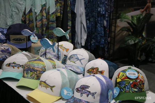 Colorful fish-print trucker hats and shirts on display at an apparel booth at the Florida Fishing Expo.