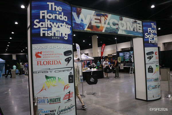 Attendees walk beneath the Florida Fishing Expo's welcome archway, lined with sponsor logos including CCA Florida and East Cape.