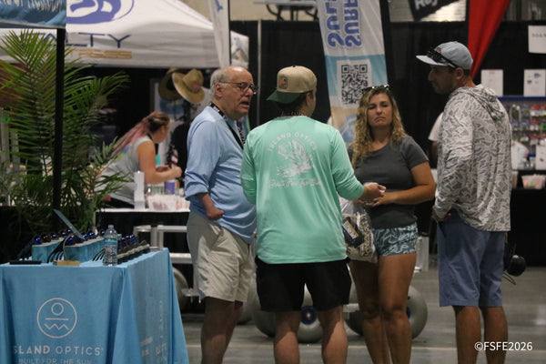 Attendees chat near the Island Optics sunglasses booth on the show floor at the Florida Fishing Expo.