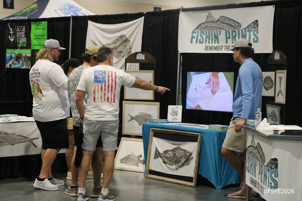 A small crowd gathers at the Fishin' Prints booth to watch a gyotaku fish-printing demonstration at the Florida Fishing Expo.