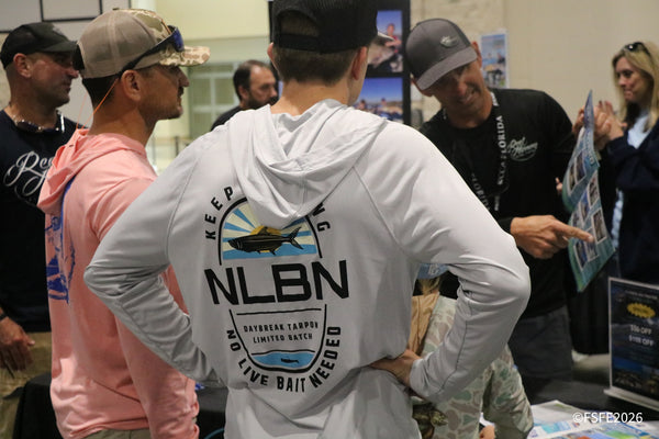 A group of attendees swaps stories near the CCA Florida booth at the Florida Fishing Expo.