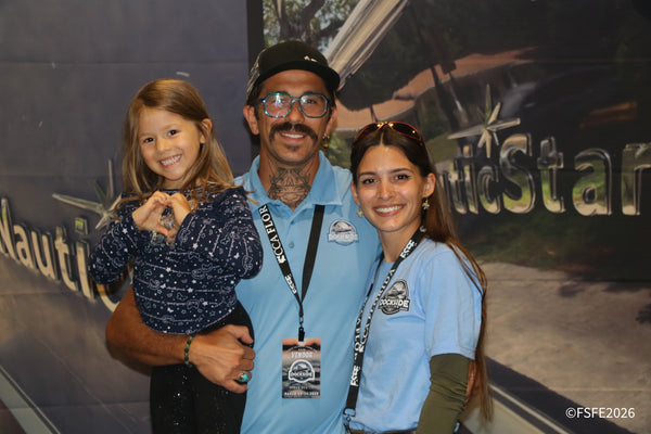 The Dockside Detailing team smiles for a family photo, complete with a heart hand sign from their youngest fan, at the Florida Fishing Expo.