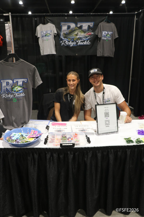 The Ricky's Tackle team smiles behind their recycled-lures booth at the Florida Fishing Expo.