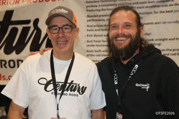 Two grinning reps pose in front of the Century Fishing Rods banner at the Florida Fishing Expo, one sporting a GoDeep hoodie.