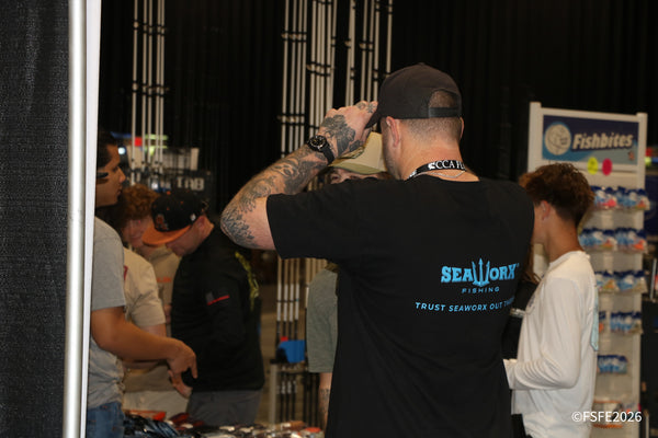 A packed rod aisle at the Florida Fishing Expo, with a SeaWorx Fishing shirt and Fishbites display in the crowd.