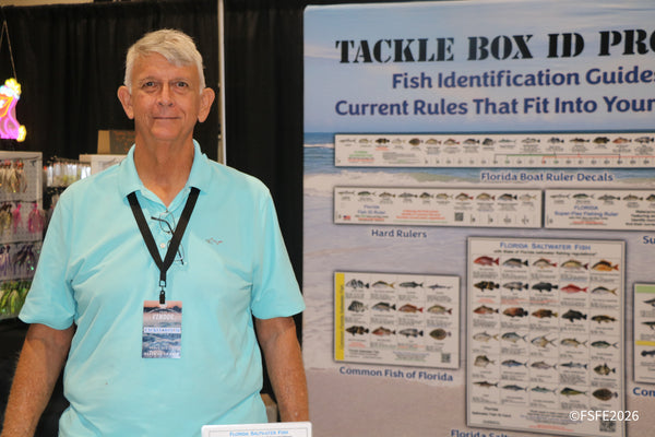 The Tackle Box ID Pro vendor stands beside his Florida fish identification guides at the Florida Fishing Expo.