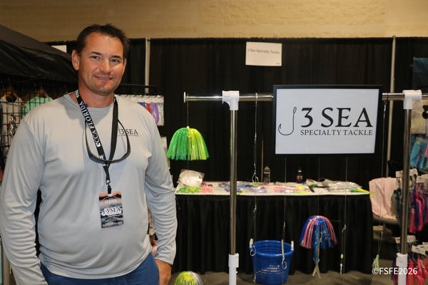 The 3 Sea Specialty Tackle vendor stands beside his colorful hand-tied lure display at the Florida Fishing Expo.