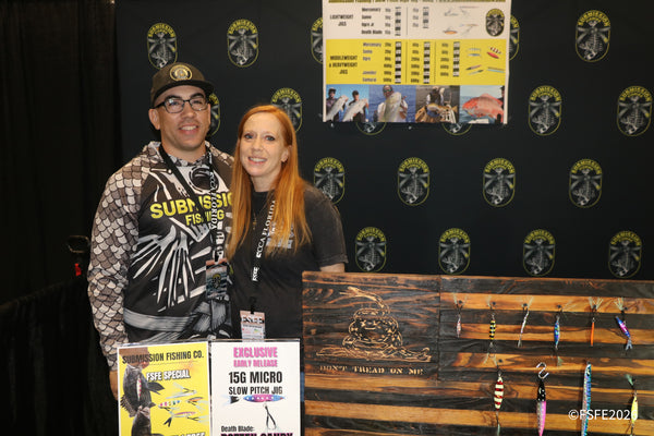 Submission Fishing Co.'s team smiles beside their slow-pitch jig display at the Florida Fishing Expo.