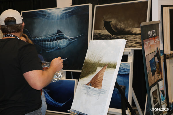 Capt. Cole Sauls live-paints a redfish tail on canvas at his marine art booth at the Florida Fishing Expo.
