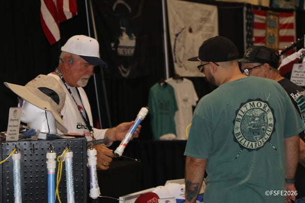 A Chum-It Fishing rep demonstrates a chum dispenser to an interested visitor at the Florida Fishing Expo.