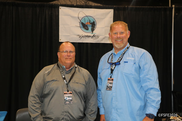 Two smiling exhibitors represent The Sinker Guy at the Florida Fishing Expo.