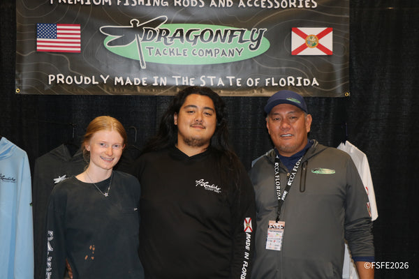 The Dragonfly Tackle Company team smiles together under their Florida-made rods banner at the Florida Fishing Expo.