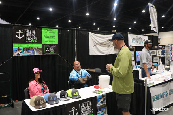 Attendees chat with the Jettie Rocks Fishing Charters team near the Fishin' Prints booth at the Florida Fishing Expo.