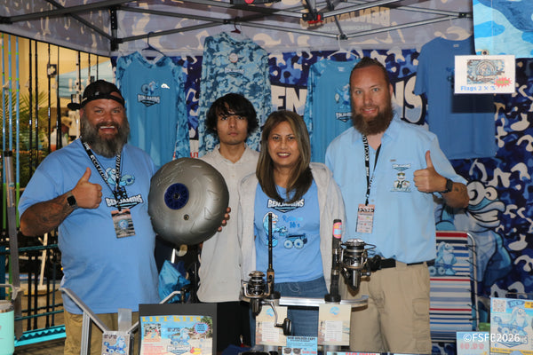 The Benjamins Beach Wheels crew flashes thumbs up in front of their off-road cart wheels and apparel at the Florida Fishing Expo.