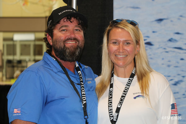 An Islamorada Fishing Products couple shares a warm smile at their Florida Fishing Expo booth.
