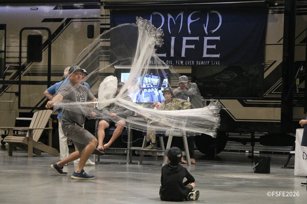 A DMFD Life member demonstrates a dramatic cast net throw near their RV display, watched closely by kids at the Florida Fishing Expo.