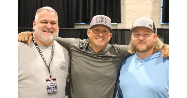 Florida Fishing Expo staff and crew share a laugh together, arms around each other, all smiles after another great show day.